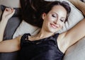 Young brunette woman in loft laying on bed smiling Royalty Free Stock Photo