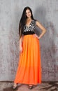 Young brunette woman in long orange skirt Royalty Free Stock Photo