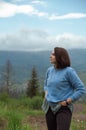 Young brunette woman looking at view at Carpathian mountains in Ukraine