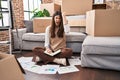 Young brunette woman moving to a new home doing finances annoyed and frustrated shouting with anger, yelling crazy with anger and Royalty Free Stock Photo