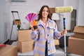 Young brunette woman painting new home walls with paint roller smiling with a happy and cool smile on face Royalty Free Stock Photo