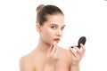 Young brunette woman with perfect clean face applying lipstick using mirror. on a white. Royalty Free Stock Photo