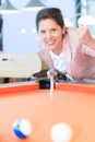 Young brunette woman playing billiards pool game