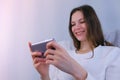 Young brunette woman is playing game on mobile phone.