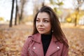 Young brunette woman portrait in autumn color walking in autumn park outdoors Royalty Free Stock Photo