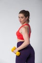 Young brunette woman posing with yellow dumbbell Royalty Free Stock Photo