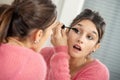 Young brunette woman putting makeup in the mirror Royalty Free Stock Photo