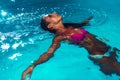 Young brunette woman relaxing in the swimming pool. Royalty Free Stock Photo