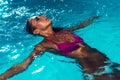 Young brunette woman relaxing in the swimming pool. Royalty Free Stock Photo