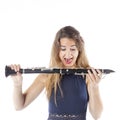 Young brunette woman seems to want to bite clarinet in studio