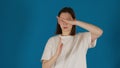 Young brunette woman shows timeout gesture standing on blue