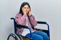 Young brunette woman sitting on wheelchair tired hands covering face, depression and sadness, upset and irritated for problem Royalty Free Stock Photo