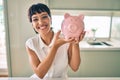 Young brunette woman smiling happy showing proud piggy bank with savings Royalty Free Stock Photo