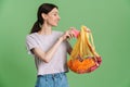 Young brunette woman smiling while posing with textile waste