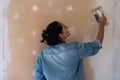 Young brunette woman smooths a plastering indoor wall Royalty Free Stock Photo