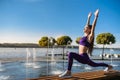 Young brunette woman in sportswear doing stretching her legs after the workout  on the lake near daytime. Healthy lifestyle Royalty Free Stock Photo