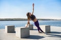 Young brunette woman in sportswear doing stretching her legs after the workout  on the lake near daytime. Healthy lifestyle Royalty Free Stock Photo