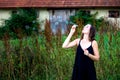 Young brunette woman standing outdoors and blowing soap bubbles Royalty Free Stock Photo