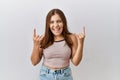 Young brunette woman standing over isolated background shouting with crazy expression doing rock symbol with hands up Royalty Free Stock Photo