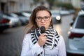 Young woman standing on street with microphone and talking