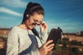 Young brunette woman take off sunglasses to view tablet outdoor