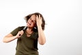 Young brunette woman with tangled unruly hair holding comb