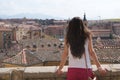 Young brunette woman tourist looking at the old city view over the roofs