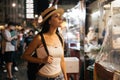 Young brunette woman traveler looking at traditional street food stalls in china town market in Asia. Royalty Free Stock Photo