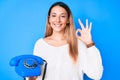 Young brunette woman using vintage telephone doing ok sign with fingers, smiling friendly gesturing excellent symbol Royalty Free Stock Photo