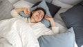 Young brunette woman waking up at morning and stretching in bed. Concept of comfort, relaxation, healthy sleeping and good start Royalty Free Stock Photo