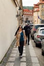 Young Brunette woman walking street.   Narrow streets  with cobblestone pavement in Prague. Medeival architecture. Royalty Free Stock Photo