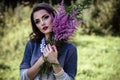 Young brunette woman walks in a summer forest park wearing stylish casual clothes Royalty Free Stock Photo