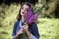 Young brunette woman walks in a summer forest park wearing stylish casual clothes Royalty Free Stock Photo