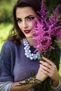 Young brunette woman walks in a summer forest park wearing stylish casual clothes Royalty Free Stock Photo