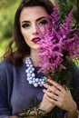 Young brunette woman walks in a summer forest park wearing stylish casual clothes Royalty Free Stock Photo