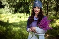 Young brunette woman walks in a summer forest park wearing stylish casual clothes Royalty Free Stock Photo