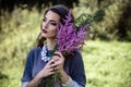 Young brunette woman walks in a summer forest park wearing stylish casual clothes Royalty Free Stock Photo