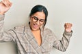 Young brunette woman wearing business jacket and glasses dancing happy and cheerful, smiling moving casual and confident listening Royalty Free Stock Photo