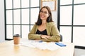 Young brunette woman wearing business style sitting on desk at office happy face smiling with crossed arms looking at the camera Royalty Free Stock Photo