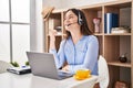 Young brunette woman wearing call center agent headset smiling with happy face looking and pointing to the side with thumb up Royalty Free Stock Photo