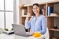Young brunette woman wearing call center agent headset smiling happy and positive, thumb up doing excellent and approval sign Royalty Free Stock Photo