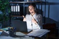 Young brunette woman wearing call center agent headset working late at night approving doing positive gesture with hand, thumbs up Royalty Free Stock Photo