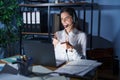 Young brunette woman wearing call center agent headset working late at night pointing fingers to camera with happy and funny face Royalty Free Stock Photo