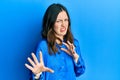 Young brunette woman wearing casual blue shirt disgusted expression, displeased and fearful doing disgust face because aversion Royalty Free Stock Photo