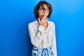 Young brunette woman wearing casual clothes and glasses bored yawning tired covering mouth with hand Royalty Free Stock Photo