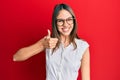 Young brunette woman wearing casual clothes and glasses doing happy thumbs up gesture with hand Royalty Free Stock Photo