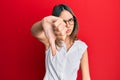 Young brunette woman wearing casual clothes and glasses looking unhappy and angry showing rejection and negative with thumbs down Royalty Free Stock Photo