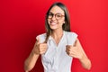 Young brunette woman wearing casual clothes and glasses success sign doing positive gesture with hand, thumbs up smiling and happy Royalty Free Stock Photo