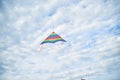 Young brunette woman, wearing casual clothes green t-shirt, playing with colorful kite on green field meadow in summer, running, Royalty Free Stock Photo