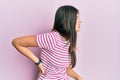 Young brunette woman wearing casual clothes over pink background suffering of backache, touching back with hand, muscular pain Royalty Free Stock Photo